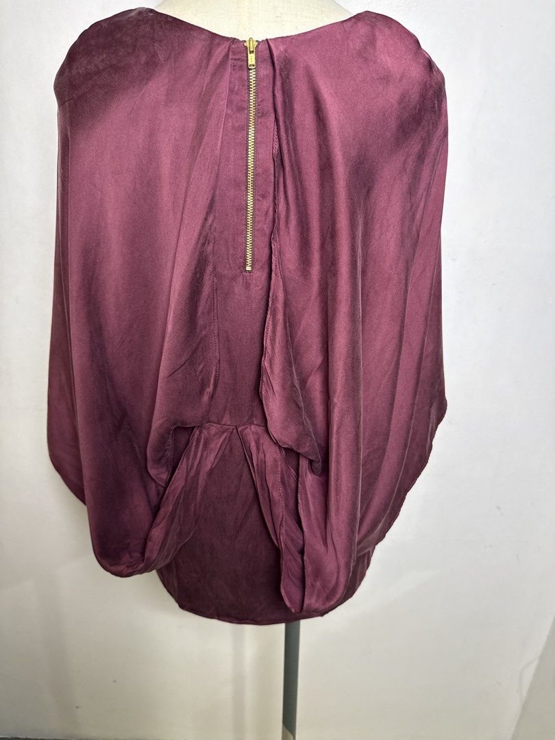 Germain Mulberry Silk Cape Blouse Burgundy (Category: Blouses) located in Quezon City. Submitted by dropdeadprices (Listing ID 1470859189, Image 3). Description: - Brand/Style: Germain burgundy mulberry silk blouse - Material: Luxurious mulberry silk with soft sheen and polyester lining - Design: Elegant cape overlay, short sleeves, and scoop neckline - Closure: Convenient exposed gold zipper down the back - Sizing: Size 38 / UK 10 / USA 2 / Ital