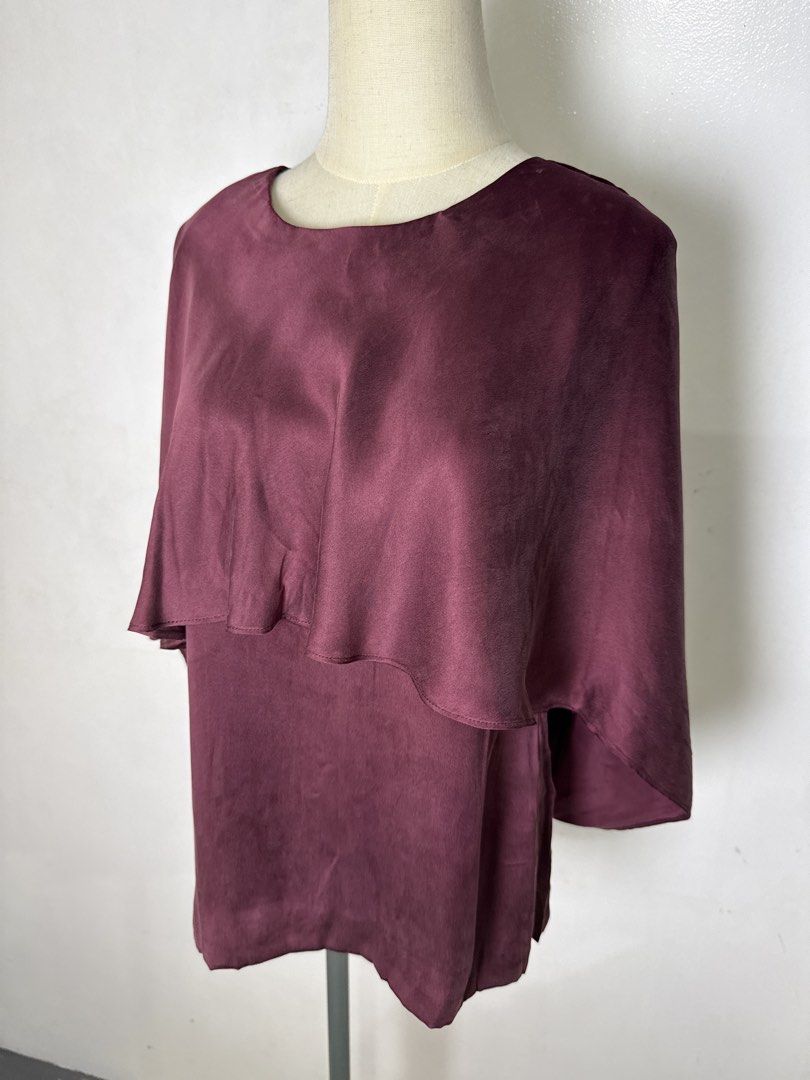 Germain Mulberry Silk Cape Blouse Burgundy (Category: Blouses) located in Quezon City. Submitted by dropdeadprices (Listing ID 1470859189, Image 2). Description: - Brand/Style: Germain burgundy mulberry silk blouse - Material: Luxurious mulberry silk with soft sheen and polyester lining - Design: Elegant cape overlay, short sleeves, and scoop neckline - Closure: Convenient exposed gold zipper down the back - Sizing: Size 38 / UK 10 / USA 2 / Ital