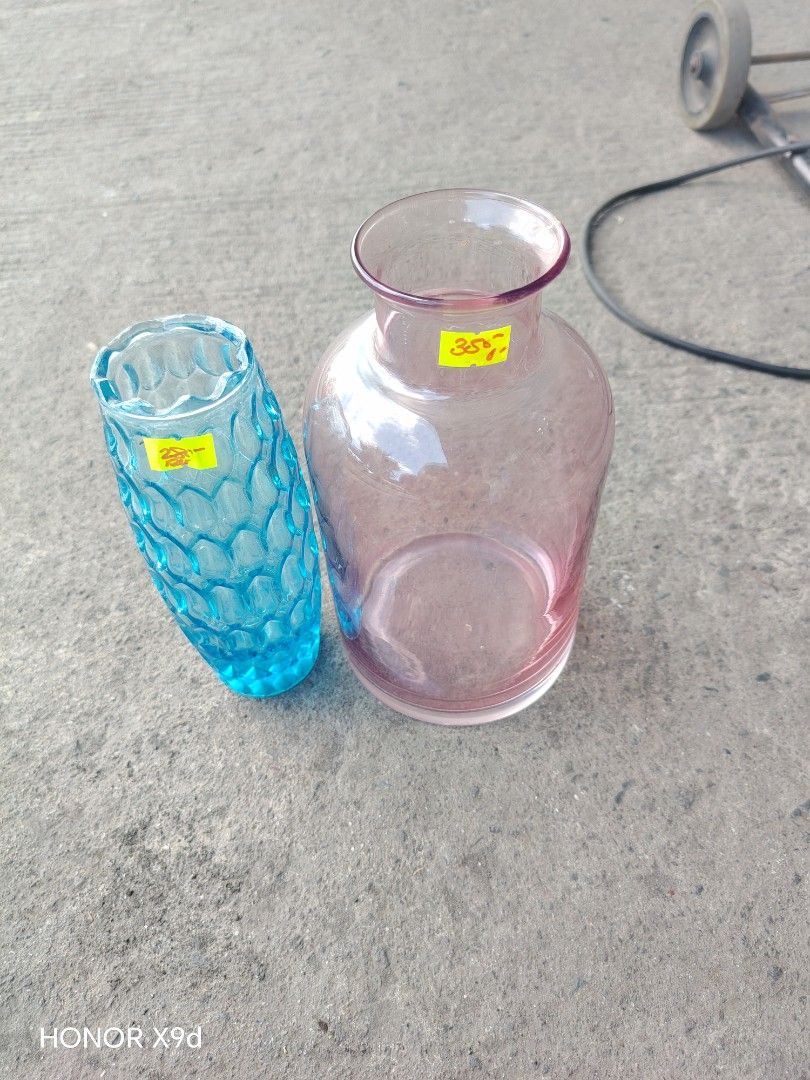Glass Vases Blue and Pink Set (Category: Vases & Decorative Bowls) located in Manila. Submitted by mightypenguin_44c1b5 (Listing ID 1470789025, Image 1). Description: Two glass vases 380 per piece in different styles and colours. One is textured turquoise blue with a tall, slender shape. The other is smooth pink with a wide body and narrow neck. Yellow price stickers still attached on both pieces. Nice decor items for flowers or empty display..
