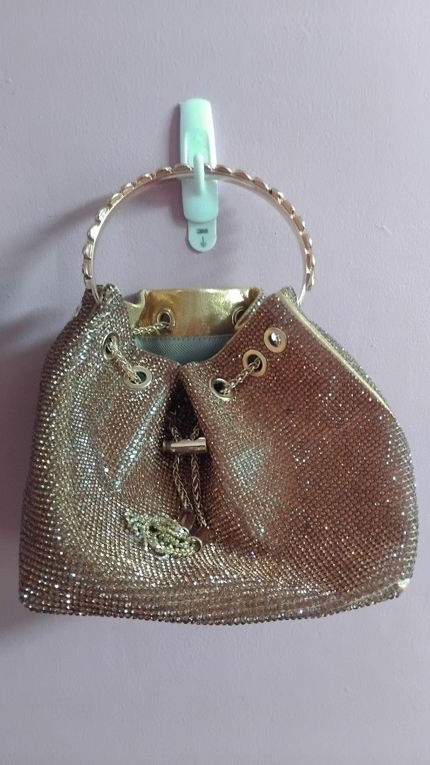 GOLD RHINESTONE BUCKET BAG (Category: Purses & Pouches) located in Iloilo. Submitted by ayinscloset (Listing ID 1470790993, Image 1). Description: ✨ GOLD RHINESTONE BUCKET BAG FOR SALE Price: ₱650 (Negotiable) Condition: Preloved - Elegant champagne gold color - Sparkling rhinestone design - Stylish circular top handle - Long chain strap for shoulder or crossbody use - Drawstring-style closure - Interior zippered pocket - Perfect for parties, wed