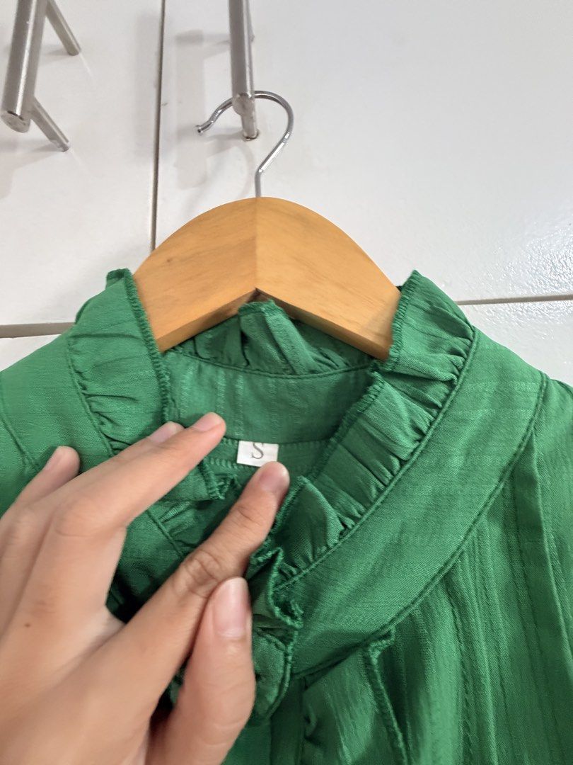 Green Ruffle Long Sleeve Button Down Blouse (Category: Longsleeves) located in Marikina City. Submitted by _bananahanaa (Listing ID 1470770349, Image 3). Description: - Color: Bright green - Design: High neck with ruffle trim and pearl-style buttons - Details: Gathered cuffs, back yoke pleating, and pleated texture - Fit: Loose and comfortable - Styling: Perfect to pair with your favorite skirts or pants.
