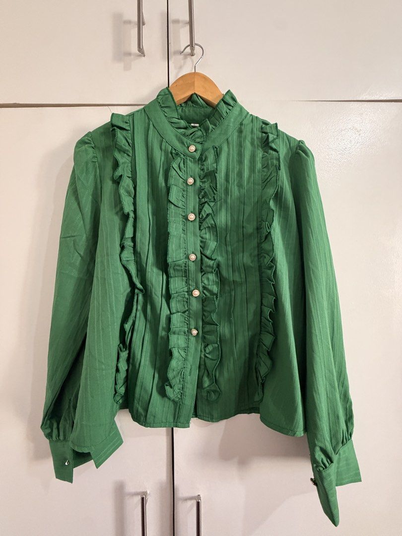 Green Ruffle Long Sleeve Button Down Blouse (Category: Longsleeves) located in Marikina City. Submitted by _bananahanaa (Listing ID 1470770349, Image 1). Description: - Color: Bright green - Design: High neck with ruffle trim and pearl-style buttons - Details: Gathered cuffs, back yoke pleating, and pleated texture - Fit: Loose and comfortable - Styling: Perfect to pair with your favorite skirts or pants.