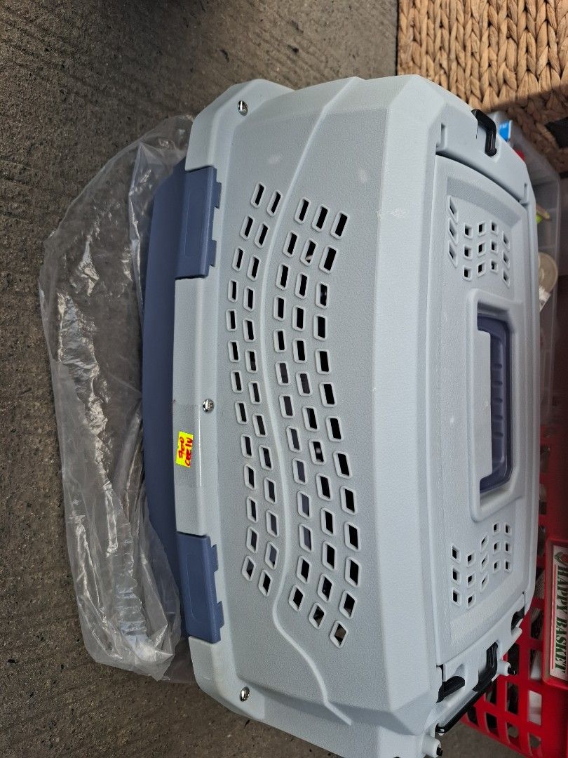 Grey and blue plastic pet carrier box (Category: Storage Boxes & Baskets) located in Manila. Submitted by rocksolid227 (Listing ID 1470776486, Image 1). Description: - Color: Grey top with dark blue bottom and matching handle - Condition: Overall clean, minimal signs of handling - Ventilation: Multiple slots across body and top lid for optimal airflow - Security: Sturdy blue carrying handle and secure latch closures - Ideal for: Vet visits and tr