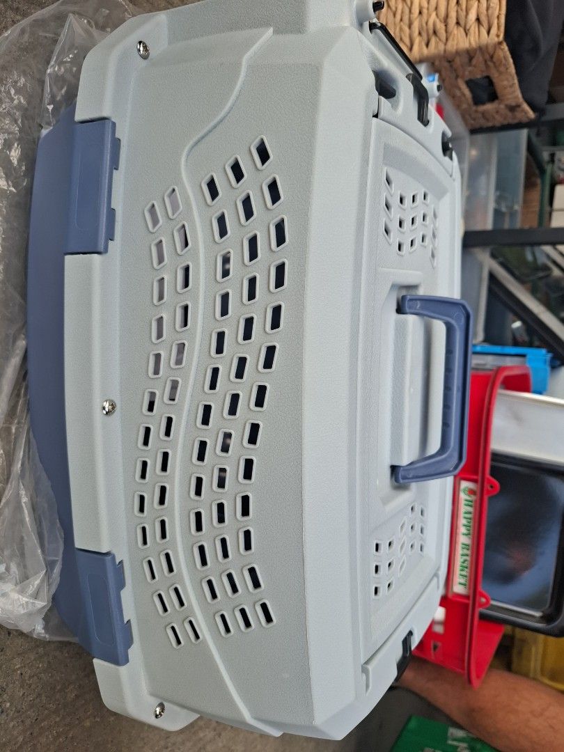 Grey and blue plastic pet carrier box (Category: Storage Boxes & Baskets) located in Manila. Submitted by rocksolid227 (Listing ID 1470776486, Image 2). Description: - Color: Grey top with dark blue bottom and matching handle - Condition: Overall clean, minimal signs of handling - Ventilation: Multiple slots across body and top lid for optimal airflow - Security: Sturdy blue carrying handle and secure latch closures - Ideal for: Vet visits and tr