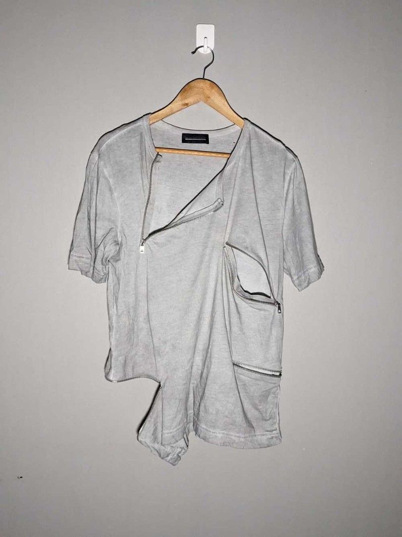Grey asymmetric zipper t-shirt (Category: Tshirts & Polo Shirts ) located in Caloocan City. Submitted by shikiibun (Listing ID 1470775540, Image 1). Description: - Color: Grey - Material: 100% Cotton (Made in Turkey) - Design: Crew neck, short sleeves with unique asymmetric hem - Details: Industrial hardware zippers and functional zipped pockets - Condition: Excellent / Like new - Perfect for an edgy, streetwear look.
