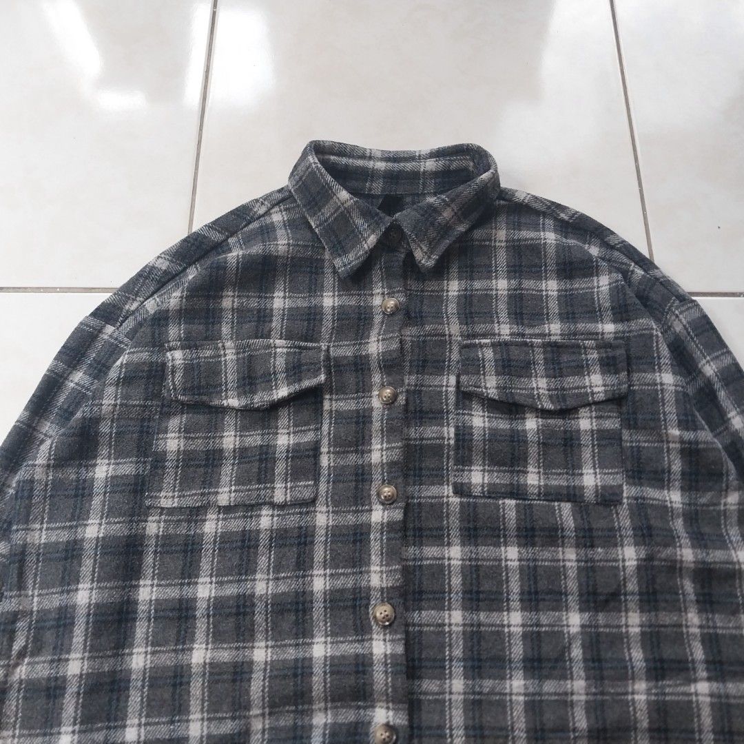 Grey Plaid Flannel Shirt Raw Hem (Category: Tshirts & Polo Shirts ) located in Cavite. Submitted by spinfits (Listing ID 1470770196, Image 3). Description: - Style: Grey and white plaid flannel with dark blue accents - Fit: Relaxed, oversized fit with a trendy raw/distressed hem - Features: Button-front closure and dual chest flap pockets - Details: Long sleeves with button cuffs - Fabric: Lightweight and comfortable cotton feel, perfect for dail