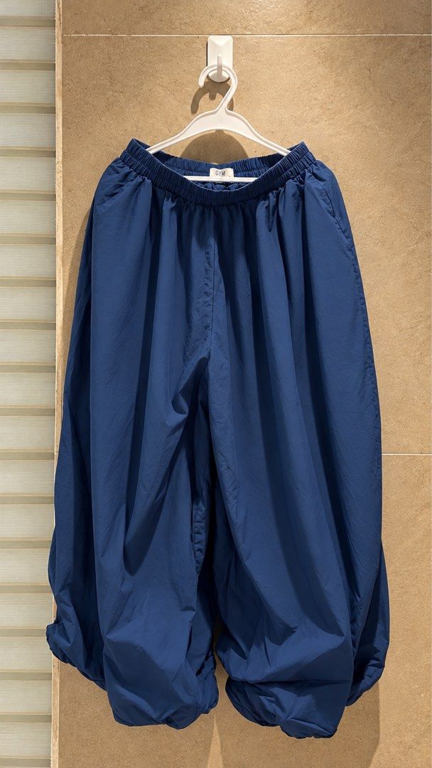 GTW Blue Balloon Parachute Pants Wide (Category: Other Bottoms) located in Manila. Submitted by wearmycloset.ph (Listing ID 1470833571, Image 1). Description: - Color: Deep blue - Style: Wide-leg parachute pants with cinched ankles and a relaxed fit - Waistband: Comfortable elastic waist with a small Gym front tag - Material: Lightweight fabric - Ideal for: Everyday casual wear, easily styled with tees and sneakers.