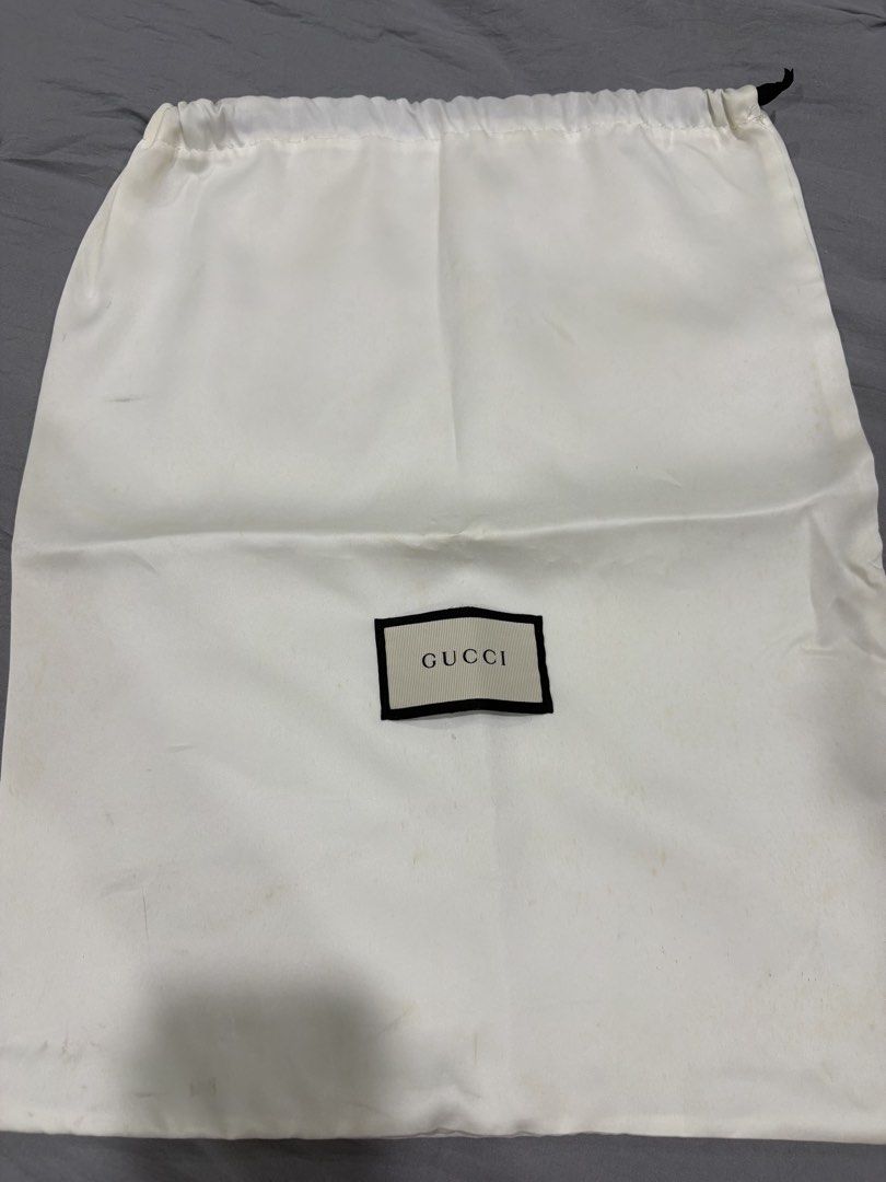 Gucci Dust Bag White Drawstring (Category: Luxury Bags & Wallets) located in Muntinlupa City. Submitted by rmsalberto (Listing ID 1470836509, Image 1). Description: - Authentic white Gucci dust bag featuring a black drawstring closure - Features the distinctive black and white woven Gucci logo patch on the front - Generously sized, ideal for storing luxury bags and accessories - Condition: Shows minor yellowish discoloration spots due to long-ter