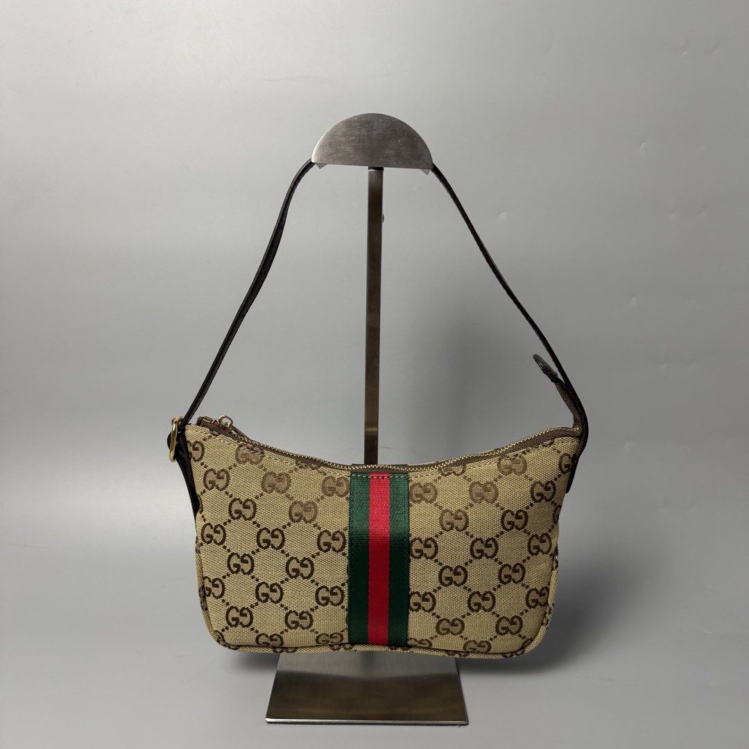 Gucci GG Canvas Web Shoulder Bag (Category: Luxury Bags & Wallets) located in Malasiqui. Submitted by fosh0fosh0 (Listing ID 1470919397, Image 2). Description: - Brand: Gucci - Style: Vintage Shoulder Bag - Material: Beige GG canvas with brown leather trim - Design: Iconic green and red web stripe, gold-tone hardware - Closure: Top zip closure - Interior: Yellow patterned fabric lining with zipper pocket and serial number tag - Size: Practical an