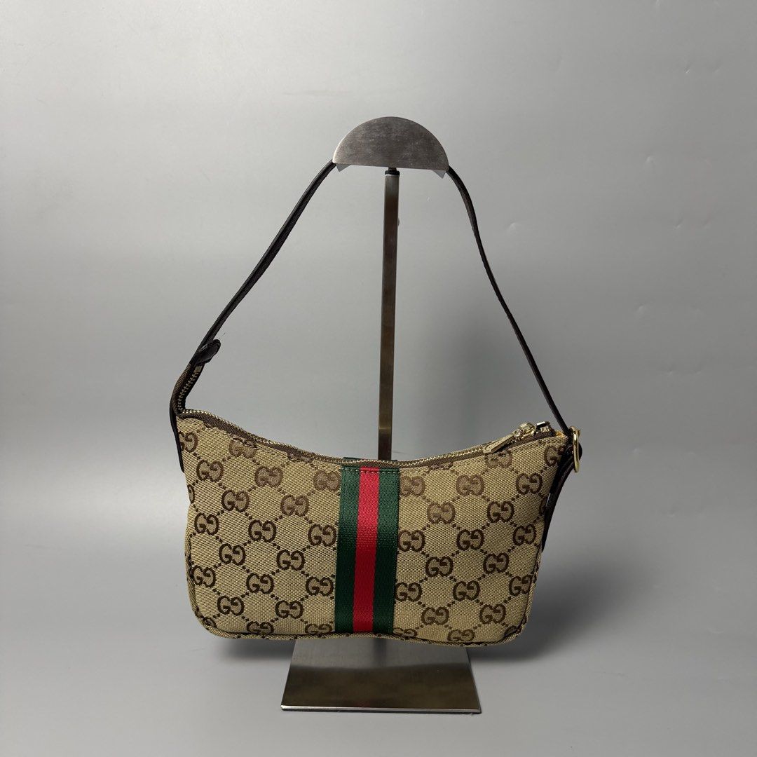 Gucci GG Canvas Web Shoulder Bag (Category: Luxury Bags & Wallets) located in Malasiqui. Submitted by fosh0fosh0 (Listing ID 1470919397, Image 1). Description: - Brand: Gucci - Style: Vintage Shoulder Bag - Material: Beige GG canvas with brown leather trim - Design: Iconic green and red web stripe, gold-tone hardware - Closure: Top zip closure - Interior: Yellow patterned fabric lining with zipper pocket and serial number tag - Size: Practical an