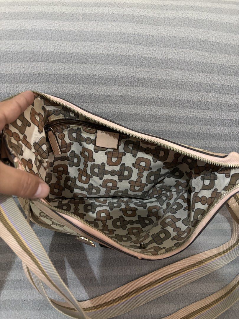 Gucci GG Monogram Canvas Shoulder Bag (Category: Luxury Bags & Wallets) located in Pasig City. Submitted by mau_llamas (Listing ID 1470840091, Image 2). Description: - Material: Beige/brown GG monogram canvas with light pink leather trim - Strap: Adjustable striped shoulder strap - Accents: Cute decorative enamel character pins on the front - Closure: Secure zip top closure - Style: Roomy and stylish daily hobo bag -Auth not guaranteed.