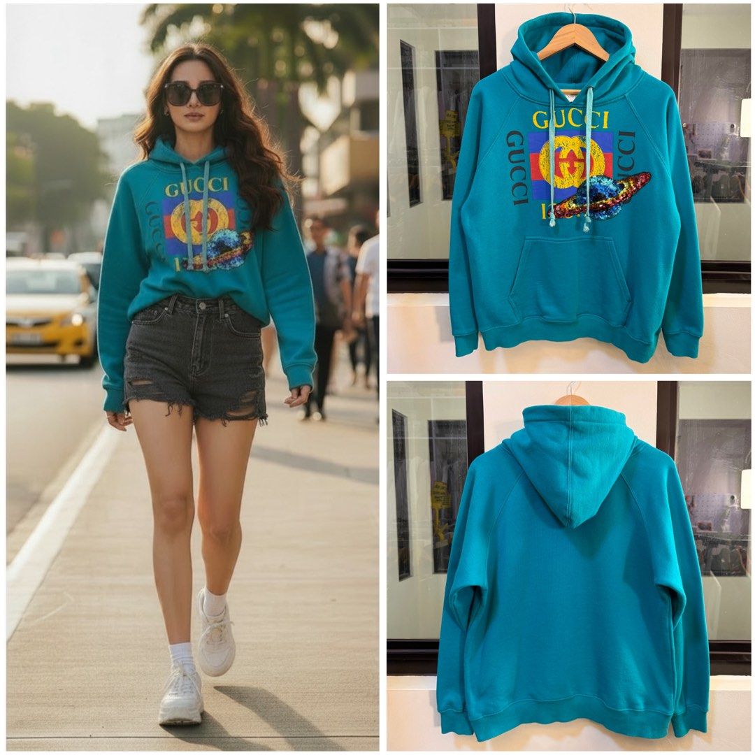 Gucci Graphic Pullover Hoodie (Category: Coats, Jackets and Outerwear) located in Paranaque City. Submitted by preluxeshop_ph (Listing ID 1470815131, Image 1). Description: Brand: Gucci •Style: Graphic Pullover Hoodie / Hooded Sweatshirt •Color: Turquoise / Teal Blue •Design Features: Vintage Gucci logo graphic print on the chest with a decorative sequin planet/appliqué detail, drawstring hood, and front kangaroo pocket •Made In: Italy •Condition