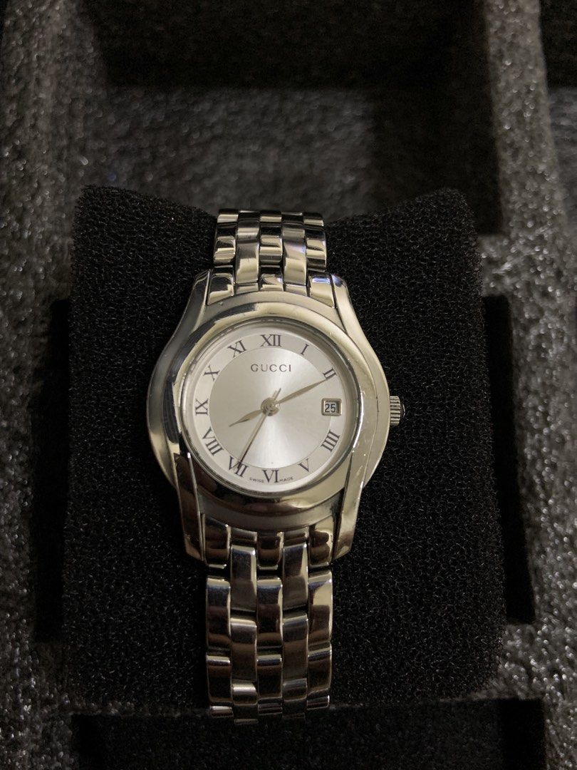 Gucci Silver Analog Watch with Roman Numerals (Category: Luxury Watches) located in Manila. Submitted by relokado (Listing ID 1470860986, Image 1). Description: - Authentic Gucci women's watch in a sleek silver-tone finish - Classic round white dial with Roman numeral markers - Convenient date window located at the 3 o'clock position - Polished link bracelet strap for a sophisticated look - Reliable Swiss made movement with a recently replaced ba
