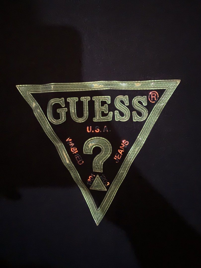 Guess Black T-Shirt with Triangle Logo (Category: Tshirts & Polo Shirts ) located in Manila. Submitted by keepercollection (Listing ID 1470832732, Image 2). Description: - Brand: Guess - Color: Dark navy blue - Design: Iconic green and red triangle logo on chest - Fit & Style: Regular fit, crew neck, short sleeves - Measurements: ~21 inches across chest, ~28 inches in length - Condition: Clean fabric, minimal signs of wear.