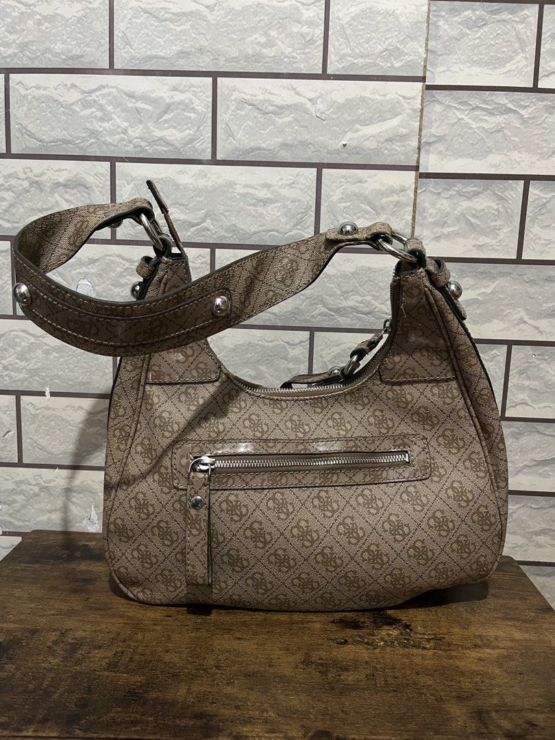 Guess Brown Monogram Shoulder Bag with Silver Hardware (Category: Shoulder Bags) located in Manila. Submitted by kuya_erick62 (Listing ID 1470760365, Image 2). Description: - Authentic Guess shoulder bag in classic brown monogram fabric - Sleek silver-tone hardware and iconic metal GUESS front logo plaque - Comfortable double shoulder straps accented with stylish stud details - Convenient exterior back zipper pocket for easy access to essentials 
