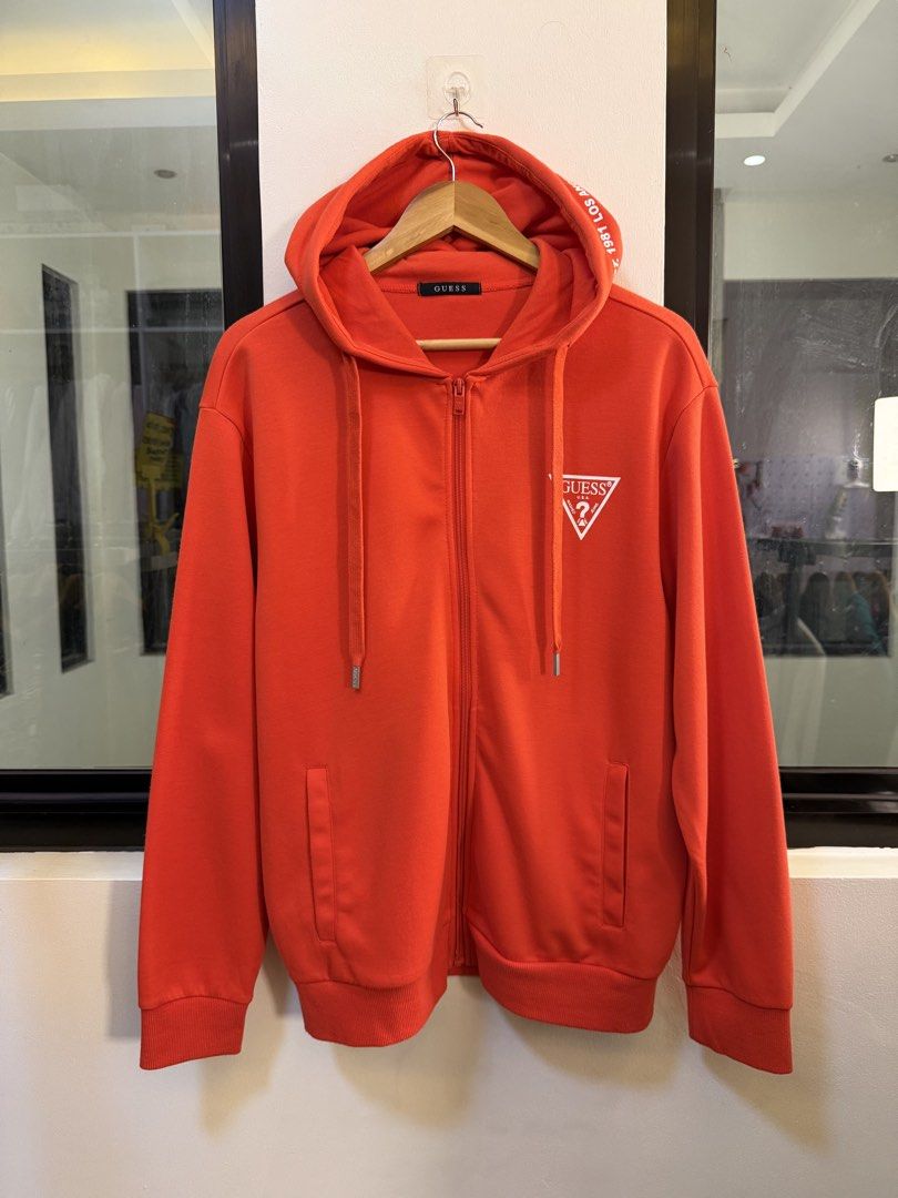 GUESS Full-Zip Hooded Sweatshirt (Category: Coats, Jackets and Outerwear) located in Paranaque City. Submitted by preluxeshop_ph (Listing ID 1470816067, Image 2). Description: Brand: GUESS •Style: Full-Zip Hooded Sweatshirt / Zip Hoodie •Color: Bright Red •Design Features: White classic GUESS triangle logo printed on the left chest, “1981 LOS ANGELES” text printed along the hood trim, full front zip closure, drawstring hood, and side hand pockets