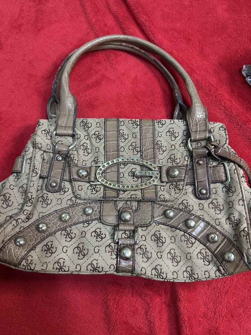 Guess monogram pattern shoulder bag with rhinestone logo (Category: Shoulder Bags) located in Manila. Submitted by goldenhorse-dafc (Listing ID 1470866866, Image 2). Description: - Brand: Guess - Color/Pattern: Beige canvas with brown monogram print - Design Details: Faux crocodile leather trim, studded accents, and rhinestone-embellished oval logo buckle - Handles: Double top handles - Interior: Cream satin lining with convenient zipper pockets 
