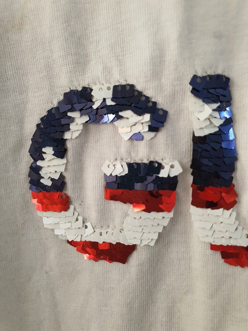 GUESS White Sequin Logo T-shirt (Category: Shirts) located in Tarlac. Submitted by resaleclub (Listing ID 1470849962, Image 3). Description: - Brand: GUESS - Color: Solid white with red, white, and blue sequin logo lettering on the front - Style: Short sleeve, casual crew neck, standard fit - Measurements: Width 18 inches, Length 25 inches - Condition: Clean and well-maintained - Versatile piece, perfect for pairing with denim or shorts - please 