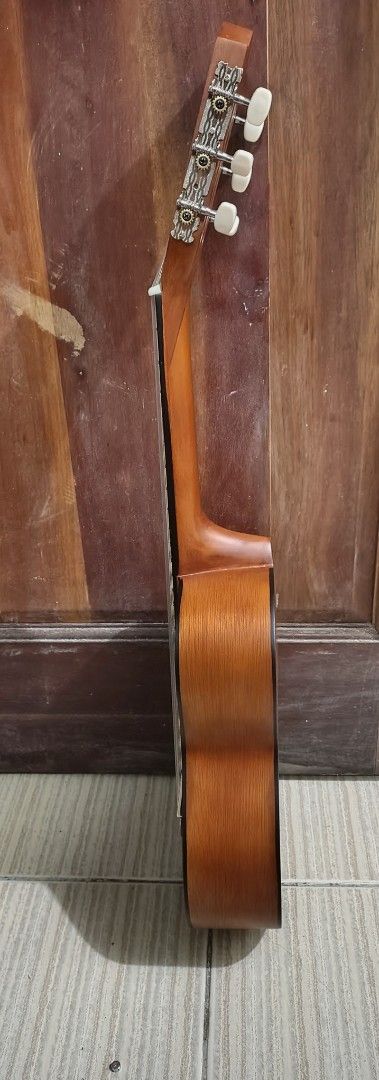 Guitale Guitarlele Classic Brown Mini Guitar (Category: Musical Instruments) located in Mandaluyong City. Submitted by kinergy04 (Listing ID 1470894861, Image 3). Description: - Guitalele Mini Classical Guitar - Color/Finish: Natural brown wooden finish - Hardware & Strings: Nylon strings with a classic slotted headstock - Design: Compact body shape, ideal for travel and practice on the go - Condition: Plays fine; note there is one small ding nea