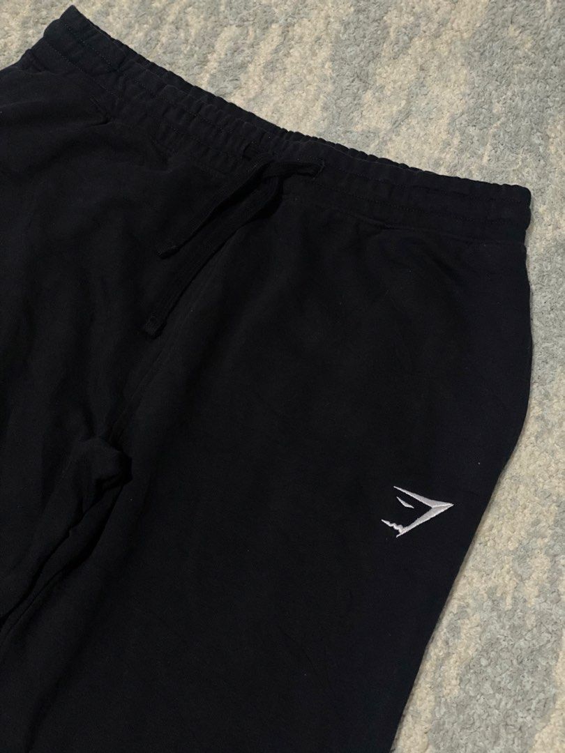 Gymshark Black Sweatpants Joggers Size M (Category: Joggers) located in Manila. Submitted by kuya_moto (Listing ID 1470827646, Image 2). Description: - Brand: Gymshark - Color: Black - Size: Medium - Material: 80% Cotton, 20% Polyester - Origin: Made in Bangladesh - Features: Soft fabric, elastic waistband with adjustable drawstring, embroidered white logo on the left leg, and ribbed ankle cuffs - Condition: Great for workouts or casual wear.