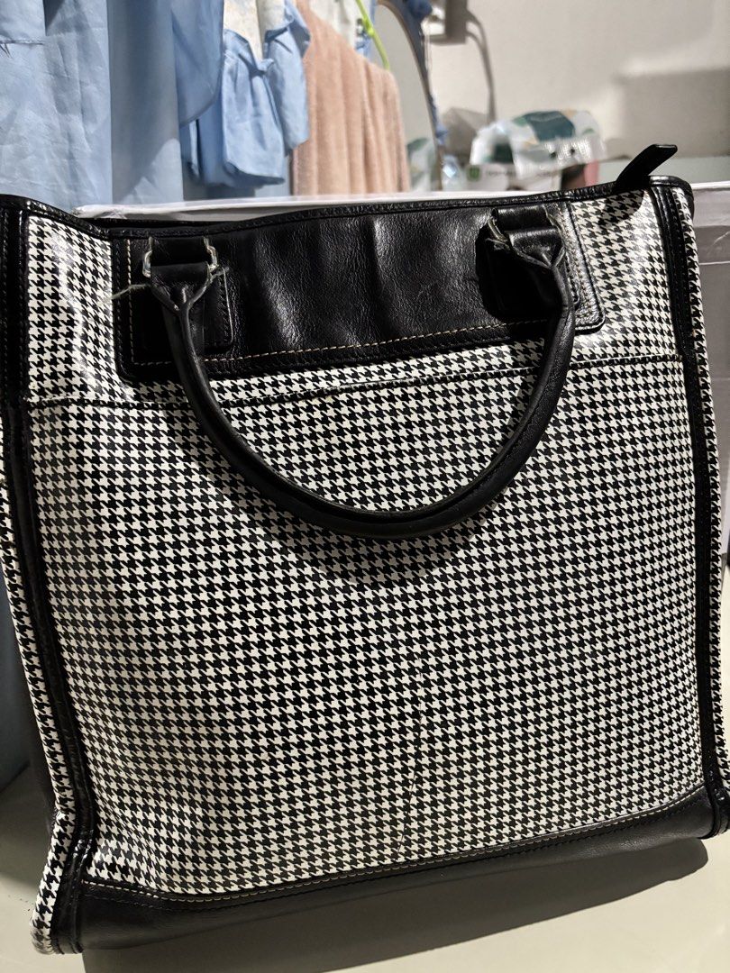HAZZYS Black and White Houndstooth Tote Bag (Category: Tote Bags) located in Rizal. Submitted by va_nes_sa_ (Listing ID 1470819949, Image 3). Description: - Brand: HAZZYS - Design: Classic black and white houndstooth pattern with black leather trim - Handles & Strap: Dual top handles plus a detachable branded shoulder guitar strap with metal hardware - Protection: Metal feet on the bottom base for durability - Expandability: Convenient zipper exp