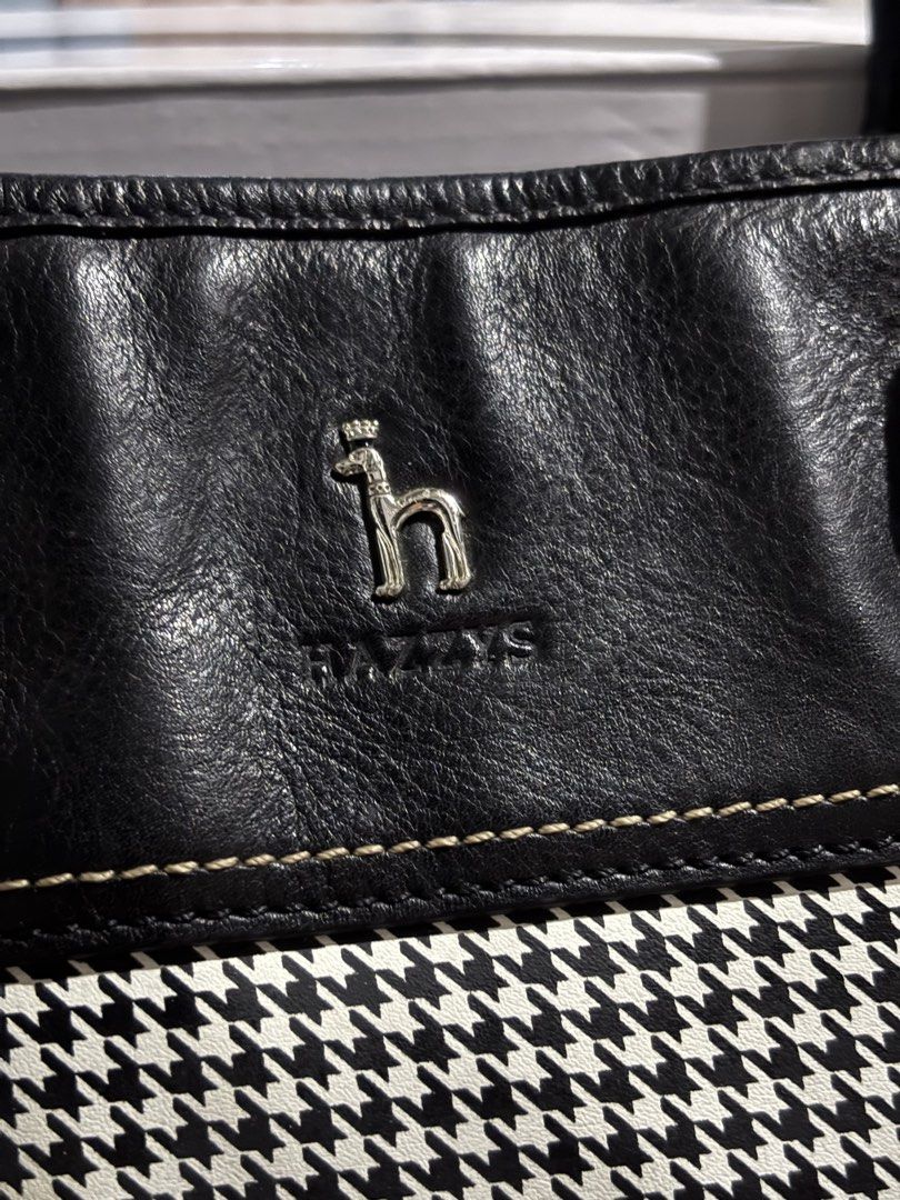 HAZZYS Black and White Houndstooth Tote Bag (Category: Tote Bags) located in Rizal. Submitted by va_nes_sa_ (Listing ID 1470819949, Image 2). Description: - Brand: HAZZYS - Design: Classic black and white houndstooth pattern with black leather trim - Handles & Strap: Dual top handles plus a detachable branded shoulder guitar strap with metal hardware - Protection: Metal feet on the bottom base for durability - Expandability: Convenient zipper exp