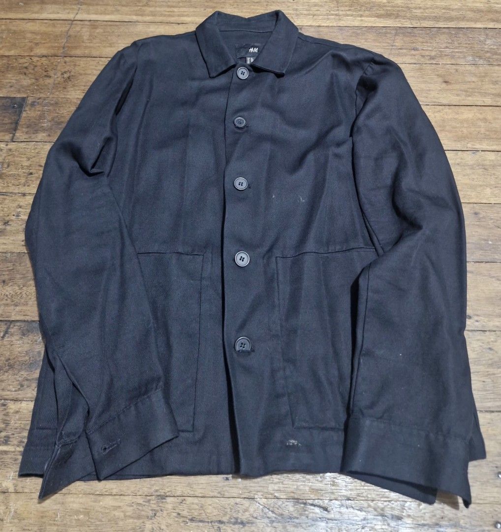 H&M Black Button-Up Overshirt Jacket (Category: Coats, Jackets and Outerwear) located in Manila. Submitted by martinezjonill (Listing ID 1470886039, Image 1). Description: - Brand: H&M - Color: Solid Black - Style: Button-up jacket with classic collar and matching buttons - Pockets: Two large front patch pockets at the waist - Sleeves: Long sleeves with button cuffs - Fabric: Structured and durable, great basic layer for cooler weather - Conditio