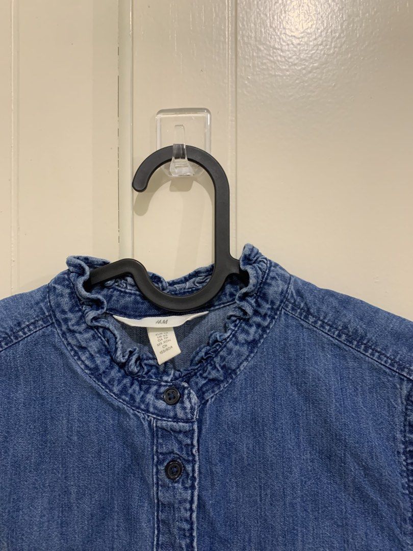 H&M Denim Ruffle Neck Blouse Size XS (Category: Blouses) located in Pasig City. Submitted by lovedbyri (Listing ID 1470861710, Image 2). Description: - Brand: H&M - Item: Denim button-down shirt - Color: Blue - Size: XS - Fit: Slim fit through the body - Details: Ruffled collar and ruffled long-sleeve cuffs, front button closure - Condition: Clean, no stains or damage spotted - Styling: Great with jeans or skirts for a casual look.