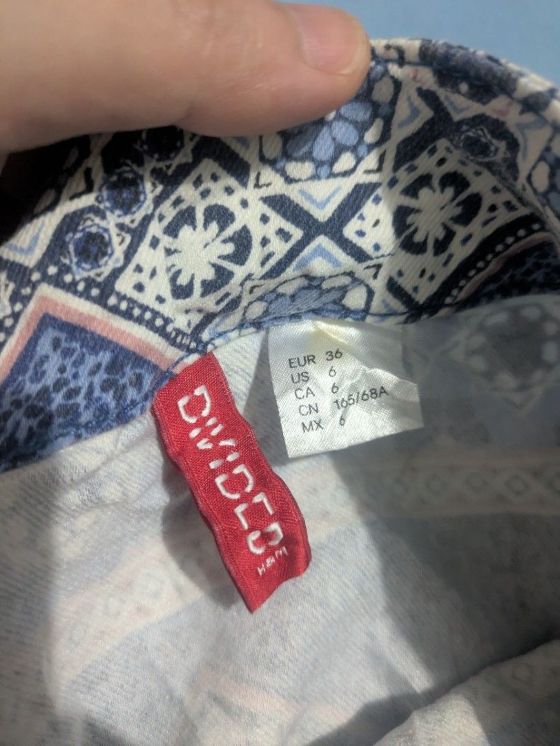 H&M Divided Blue Aztec Boho Patterned Mini Skirt (Category: Skirts) located in Bocaue. Submitted by _agentorange (Listing ID 1470915870, Image 3). Description: - Brand: H&M Divided - Size: EUR 36 / US 6 / CN 165/68A - Design: Bohemian print with geometric shapes and floral motifs - Details: Back blue zipper closure with clear button detail at the waist - Fit: Mini length, lightweight and comfortable fabric - Condition: Excellent pre-loved conditi