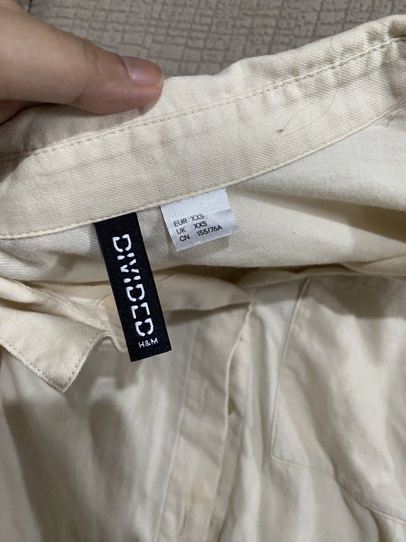 H&M Divided Cream Button-Down Shirt XXS (Category: Shirts) located in Las Pinas. Submitted by iamsayen (Listing ID 1470818198, Image 2). Description: - Brand: H&M Divided - Color: Cream - Size: XXS (EUR/UK XXS, CN 155/76A) - Style: Long sleeve button-down shirt with collar and single left chest pocket - Material: Lightweight and comfortable - Condition/Vibe: Classic everyday basic, very easy to mix and match with different outfits.