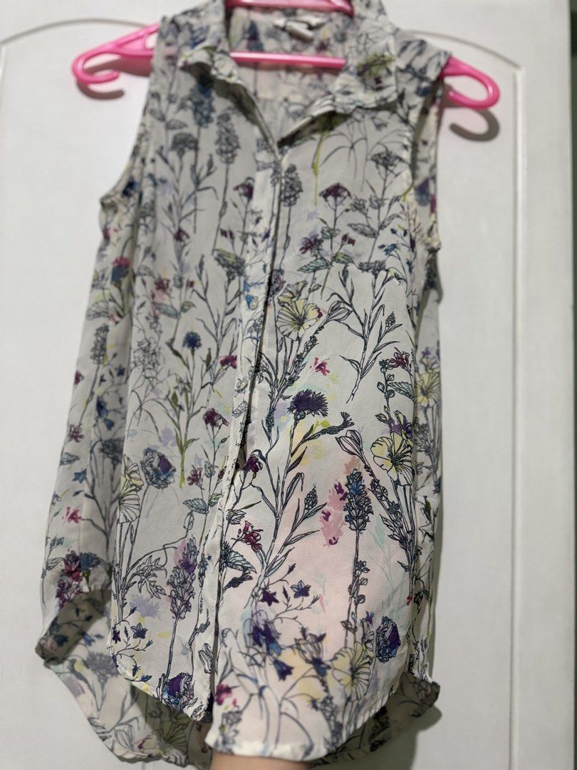 H&M Floral Sleeveless Button-Down Blouse Size US 2 (Category: Blouses) located in Manila. Submitted by melissaal82890 (Listing ID 1470893819, Image 3). Description: - Brand: H&M FITS SMALL - Style: Sleeveless button-down shirt with a collar and curved high-low hem - Design: Off-white background with a multi-colored floral and botanical print - Fabric: Lightweight and slightly sheer - Size: EUR 32, US 2, CN 155/76A - Condition: Excellent, ready to