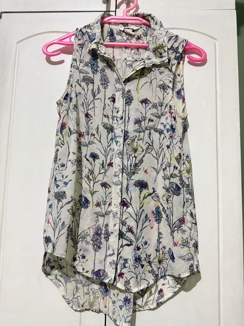 H&M Floral Sleeveless Button-Down Blouse Size US 2 (Category: Blouses) located in Manila. Submitted by melissaal82890 (Listing ID 1470893819, Image 1). Description: - Brand: H&M FITS SMALL - Style: Sleeveless button-down shirt with a collar and curved high-low hem - Design: Off-white background with a multi-colored floral and botanical print - Fabric: Lightweight and slightly sheer - Size: EUR 32, US 2, CN 155/76A - Condition: Excellent, ready to