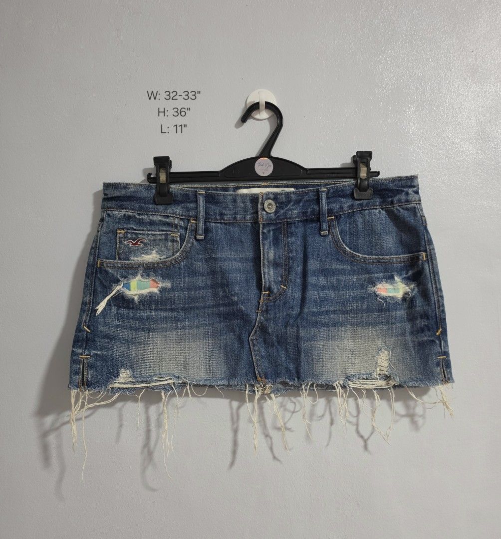 Hollister Distressed Denim micro Skirt with Rainbow Patch (Category: Skirts) located in Paranaque City. Submitted by franinnashop (Listing ID 1470795991, Image 1). Description: Declutter - Brand: Hollister - Style: Denim skirt in medium blue wash - Size: Waist 32-33 inches, length 11 inches - Details: Distressed with frayed hem, unique multi-colored patch under front rip - Pockets: Classic 5-pocket style with signature seagull logo on coin pocket