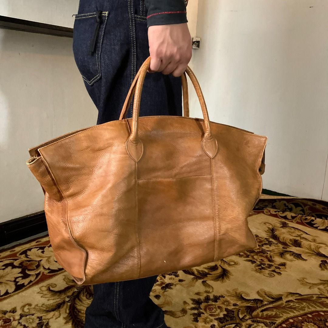 Japanese Artisan Full-Grain Leather Oversized Weekender Bag (Category: Briefcases) located in Manila. Submitted by nellyfrustrado (Listing ID 1470785010, Image 1). Description: Brand: Unmarked / Artisan Crafted Material: Full-Grain Leather. The extreme close-up reveals deep natural fat wrinkles, prominent uncorrected hide texturing, and solid leather cross-sections at the seams, confirming it is a premium full-grain leather rather than a sanded o