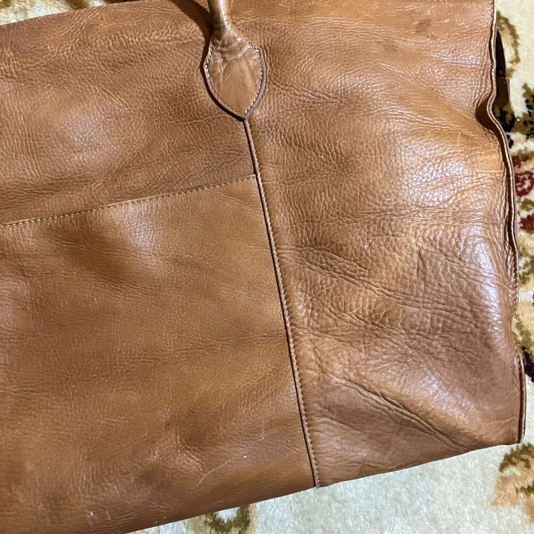 Japanese Artisan Full-Grain Leather Oversized Weekender Bag (Category: Briefcases) located in Manila. Submitted by nellyfrustrado (Listing ID 1470785010, Image 3). Description: Brand: Unmarked / Artisan Crafted Material: Full-Grain Leather. The extreme close-up reveals deep natural fat wrinkles, prominent uncorrected hide texturing, and solid leather cross-sections at the seams, confirming it is a premium full-grain leather rather than a sanded o
