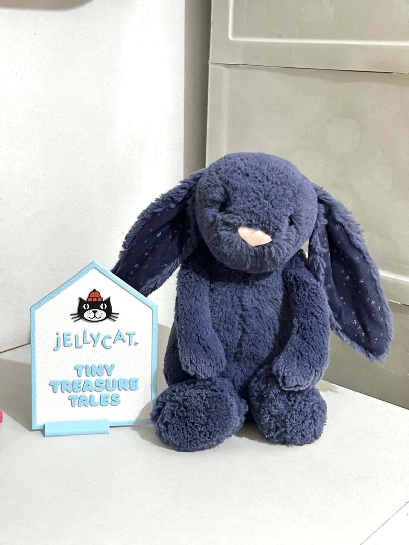 Jellycat Stardust Bunny Medium (Category: Plushies & Soft Toys) located in Cabanatuan. Submitted by tinytreasuretales (Listing ID 1470750384, Image 1). Description: - Brand: Authentic Jellycat London - Color: Navy blue with pink embroidered nose - Special Feature: Sparkly star pattern inside the ears - Condition: Excellent, clean, no stains or damage (tush tags attached with batch code EC1638) - Ideal for: Kids, gifts, and Jellycat collectors.