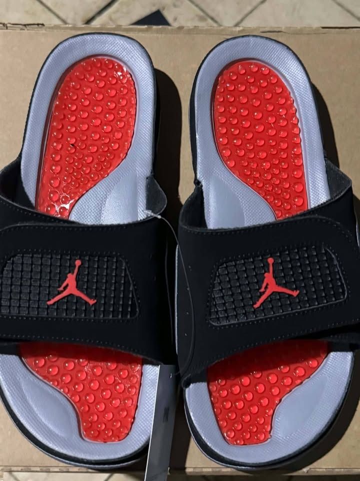 Jordan Hydro Slides Black Red Grey (Category: Slippers & Slides) located in Caloocan City. Submitted by vada920 (Listing ID 1470886092, Image 1). Description: - Brand: Jordan Hydro 4 Retro - Colorway: Black, red, and grey with bright red Jumpman logo - Condition: Brand new with original store tag attached - Features: Adjustable top strap and textured red massaging footbed bubbles - Ideal for: Post-workout recovery and casual everyday lounging - A