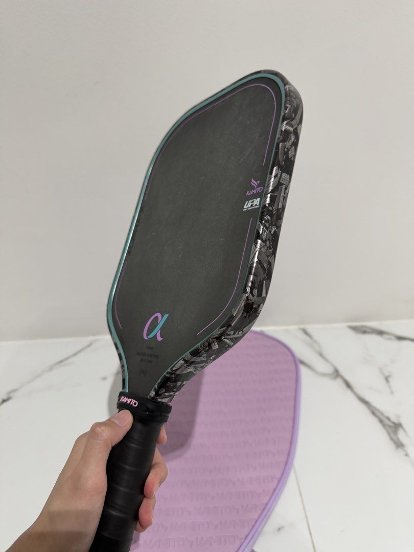 Kamito Alpha-X 16mm Pickleball Paddle (Category: Racket and Ball Sports) located in Valenzuela. Submitted by alyssa_3 (Listing ID 1470796669, Image 3). Description: Kamito Alpha-X pickleball paddle, 16mm thickness. Master control and max spin performance. UPA pro certified. Carbon forged raw texture on the edges with a black face, teal and purple accents. Matching purple Kamito zippered cover included. Wrapped black handle with a pink Kamito rubb