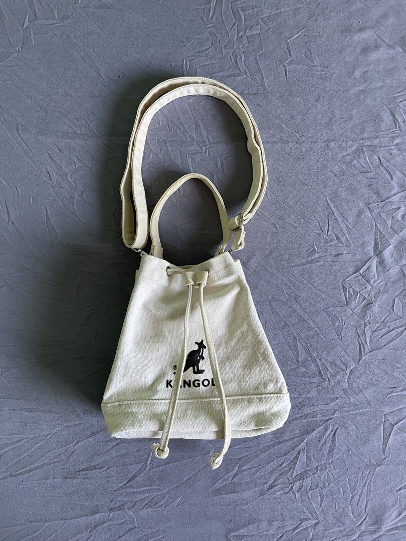 Kangol Canvas Bucket Bag Off White (Category: Shoulder Bags) located in Cagayan de Oro. Submitted by jekdels05 (Listing ID 1470745116, Image 1). Description: - Brand: Kangol - Color: Off-white canvas with black embroidered kangaroo logo - Closure: Drawstring top - Interior: Includes a handy inside pocket with the official brand patch - Straps: Comes with a top handle plus an adjustable and detachable shoulder strap with chic silver-tone hardware 