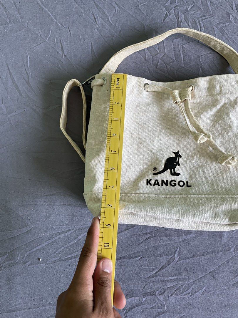 Kangol Canvas Bucket Bag Off White (Category: Shoulder Bags) located in Cagayan de Oro. Submitted by jekdels05 (Listing ID 1470745116, Image 3). Description: - Brand: Kangol - Color: Off-white canvas with black embroidered kangaroo logo - Closure: Drawstring top - Interior: Includes a handy inside pocket with the official brand patch - Straps: Comes with a top handle plus an adjustable and detachable shoulder strap with chic silver-tone hardware 