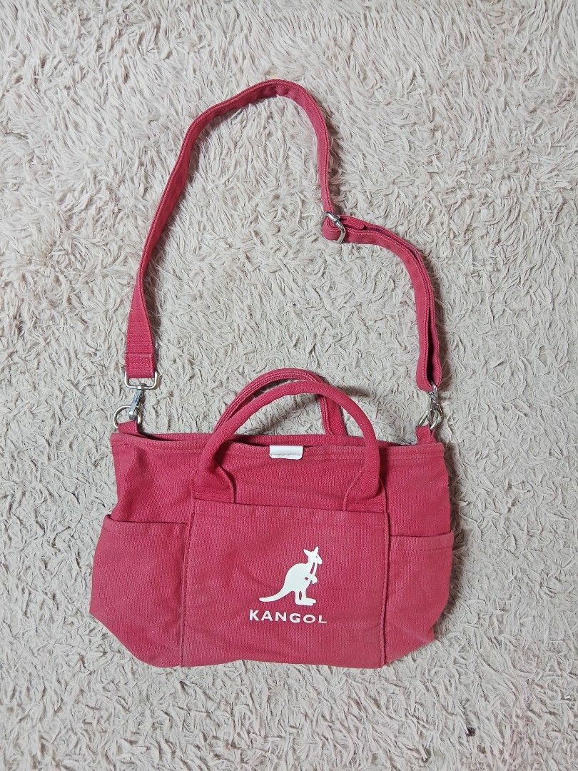 Kangol Red Canvas Tote Crossbody Bag (Category: Tote Bags) located in Lucban. Submitted by aeronroyyy (Listing ID 1470809699, Image 1). Description: - Brand: Kangol - Color: Bright red with white kangaroo logo - Material: 100% cotton canvas (Made in China) - Carry Options: Dual top handles and adjustable shoulder strap - Exterior: Front pocket and two side slip pockets - Closure: Snap button main compartment - Interior: Red logo-lined fabric with