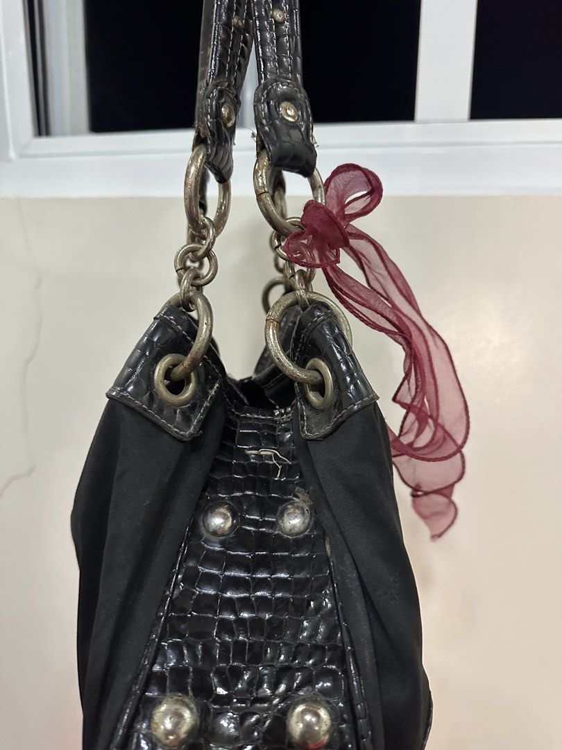 Kathy Van Zeeland Black Shoulder Bag (Category: Shoulder Bags) located in Manila. Submitted by goldenhorse-dafc (Listing ID 1470867398, Image 2). Description: - Brand: Kathy Van Zeeland - Material: Black fabric with faux croc-embossed trim - Straps: Double chain and faux leather with metallic rings - Hardware: Gold and silver-tone, featuring a crown zipper pull and heart charm - Interior: Bright gold fabric lining with zip and slip pockets - Extr