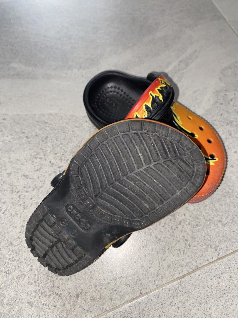 Kids Crocs Flame Print Clogs (Category: Babies & Kids Fashion) located in Tagkawayan. Submitted by gailejoves (Listing ID 1470822766, Image 2). Description: - Brand/Style: Kids Crocs Clogs with a cool black, orange, and yellow flame graphic - Comfort: Iconic Crocs comfort footbed with breathable toe box ventilation ports - Fit: Easy slip-on design with a secure pivoting heel strap - Condition: Soles show only light dirt from walking, overall grea