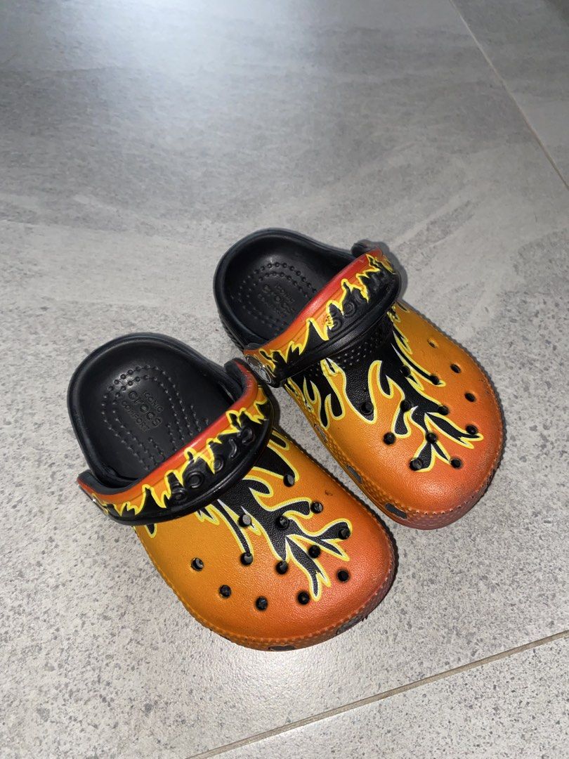 Kids Crocs Flame Print Clogs (Category: Babies & Kids Fashion) located in Tagkawayan. Submitted by gailejoves (Listing ID 1470822766, Image 1). Description: - Brand/Style: Kids Crocs Clogs with a cool black, orange, and yellow flame graphic - Comfort: Iconic Crocs comfort footbed with breathable toe box ventilation ports - Fit: Easy slip-on design with a secure pivoting heel strap - Condition: Soles show only light dirt from walking, overall grea