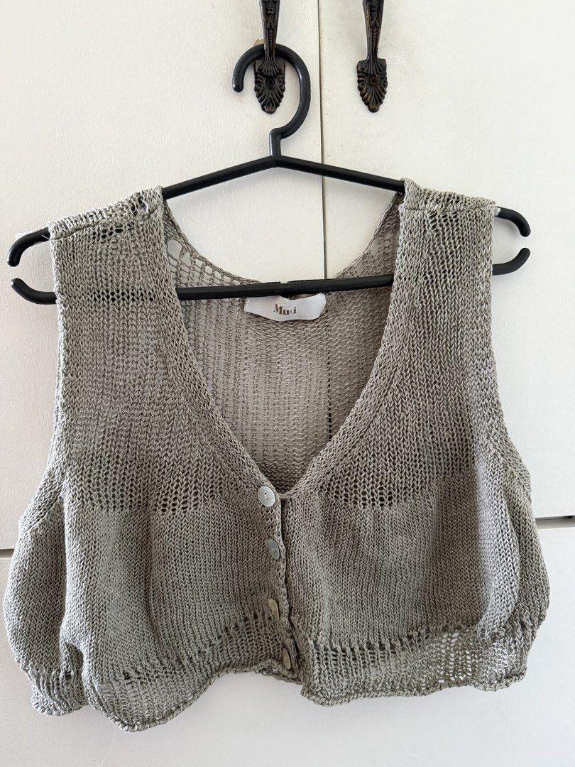 Knit Vest Cropped (Category: Sleeveless) located in Manila. Submitted by mnlclaudia (Listing ID 1470790913, Image 1). Description: - Brand: Mu:i - Style: Cropped knit vest with V-neck and button-up front - Material: Lightweight, breathable open-weave knit - Versatility: Great for layering over tees or wearing on its own - Color: Neutral grey, ideal for warm weather outfits.