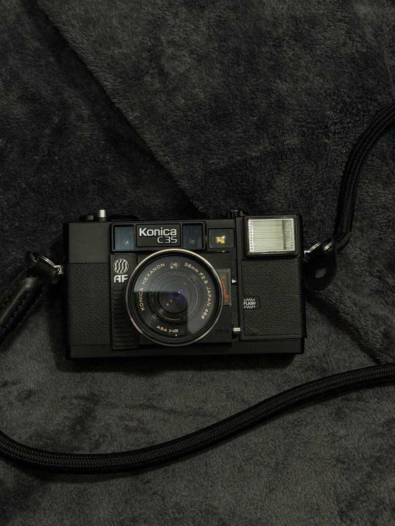 Konica C35 AF 35mm Film Camera with Flash and Strap (Category: Cameras) located in Las Pinas. Submitted by myqanorella (Listing ID 1470930400, Image 1). Description: - Model: Konica C35 AF vintage compact film camera (Black) - Last CLA: July 31, 2026 - Lens: Sharp 38mm f/2.8 Hexanon lens - Features: Built-in pop-up flash and easy autofocus point-and-shoot setup - Condition: Tested and working (battery compartment and film door checked) - Inclusio