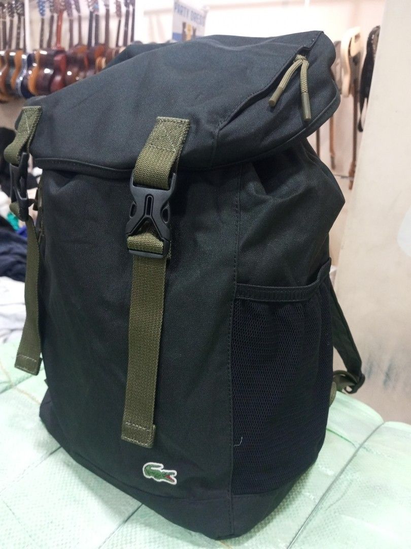 Lacoste Black Canvas Backpack with Green Straps (Category: Backpacks) located in Bacolod City. Submitted by exequelgra46775 (Listing ID 1470763467, Image 2). Description: - Authentic Lacoste black canvas backpack - Roll-top flap design with secure drawstring pull cords - Stylish olive green adjustable straps with plastic buckle closures - Convenient dual side mesh pockets for water bottles or essentials - Signature embroidered crocodile logo near