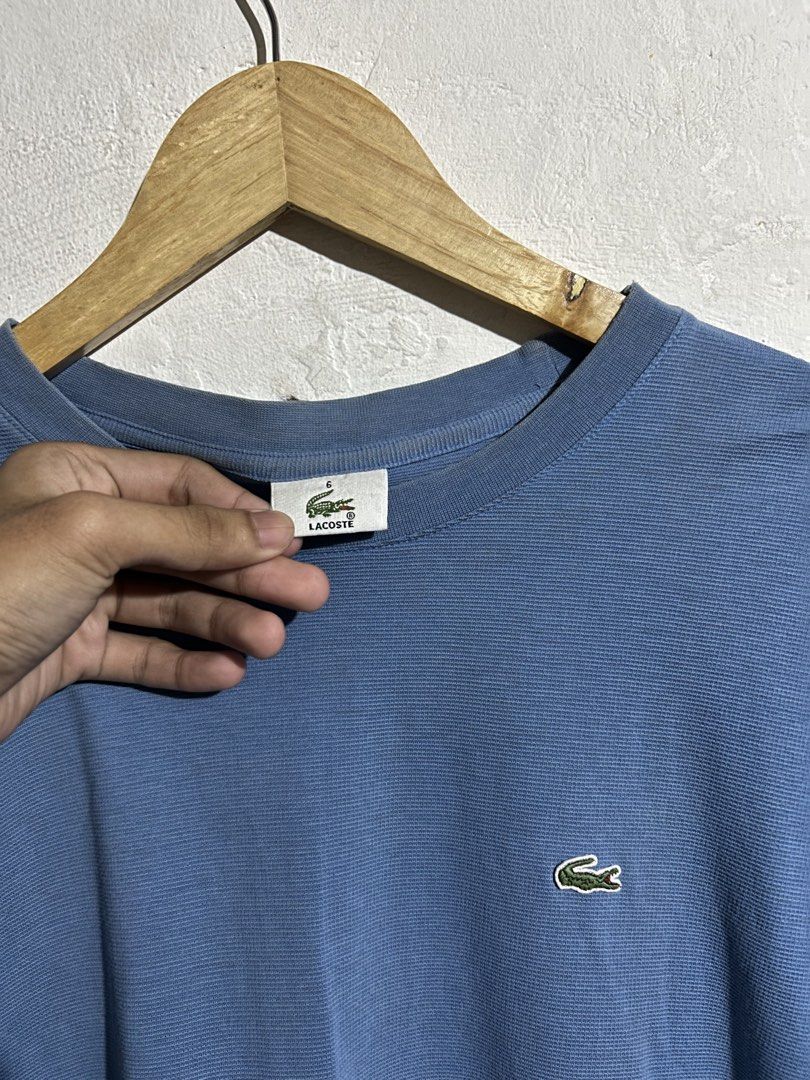 Lacoste Blue T-Shirt Size 6 Devanlay (Category: Shirts) located in Manila. Submitted by romnick907 (Listing ID 1470819183, Image 2). Description: - Brand: Lacoste (Manufactured by Devanlay) - Color: Light Blue - Size: 6 (Tag inside collar) - Material/Style: Textured fabric, classic crew neck, short sleeves - Details: Small embroidered crocodile logo on the chest - Condition: Clean overall, with minimal wear on the collar ribbing.