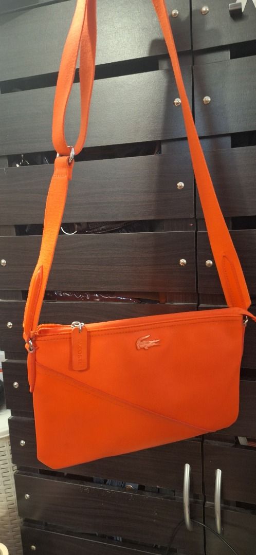 LACOSTE Body Bag (Category: Cross-body Bags) located in General Trias. Submitted by aeunice (Listing ID 1470809391, Image 1). Description: Brand: Lacoste In Good Condition. Authentic Lacoste crossbody bag in a vibrant orange color, perfect for adding a pop of color to your everyday style. Compact, stylish and easy to carry, it’s a great choice for casual outings and daily use. Meet up / Shipping via Lalamove, JnT, Gogo Express & LBC .