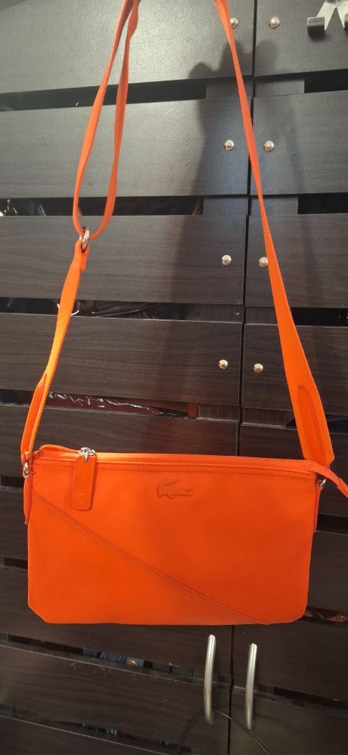 LACOSTE Body Bag (Category: Cross-body Bags) located in General Trias. Submitted by aeunice (Listing ID 1470809391, Image 3). Description: Brand: Lacoste In Good Condition. Authentic Lacoste crossbody bag in a vibrant orange color, perfect for adding a pop of color to your everyday style. Compact, stylish and easy to carry, it’s a great choice for casual outings and daily use. Meet up / Shipping via Lalamove, JnT, Gogo Express & LBC .